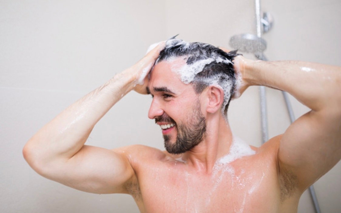 man showering hair hot